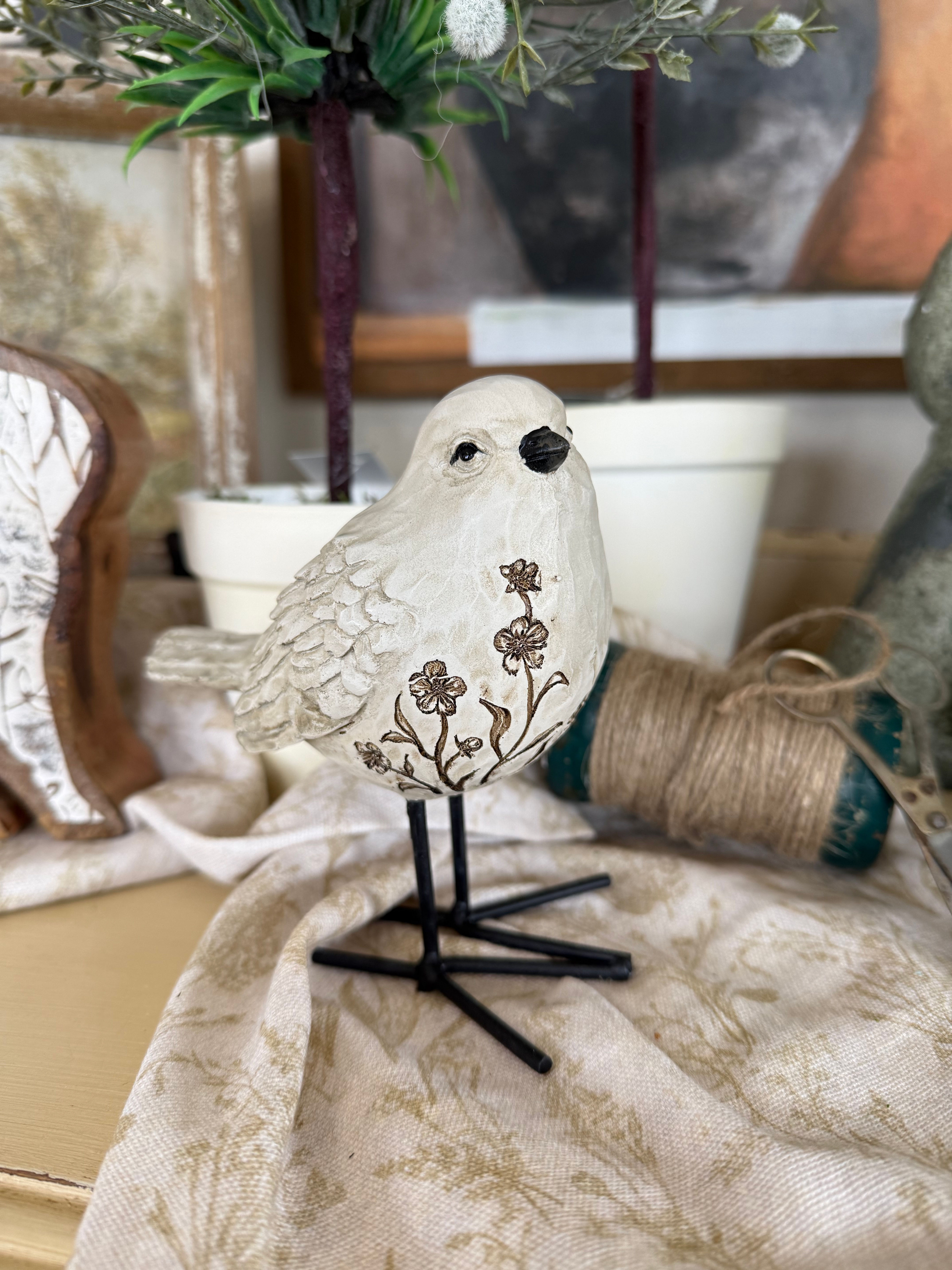 5.2"x4.75"x2.75" resin bird standing on metal legs, taupe finish with gold carved floral details