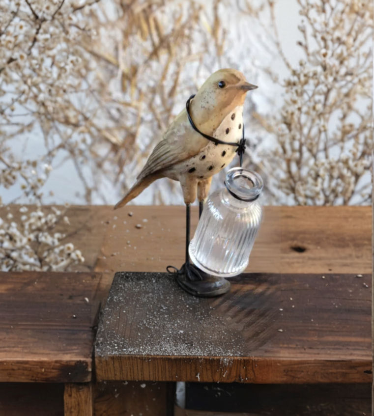 5.5" x 3" x 6.5" resin bird painted tan on an iron base with a glass bottle wired around its neck, use for flowers or herbs