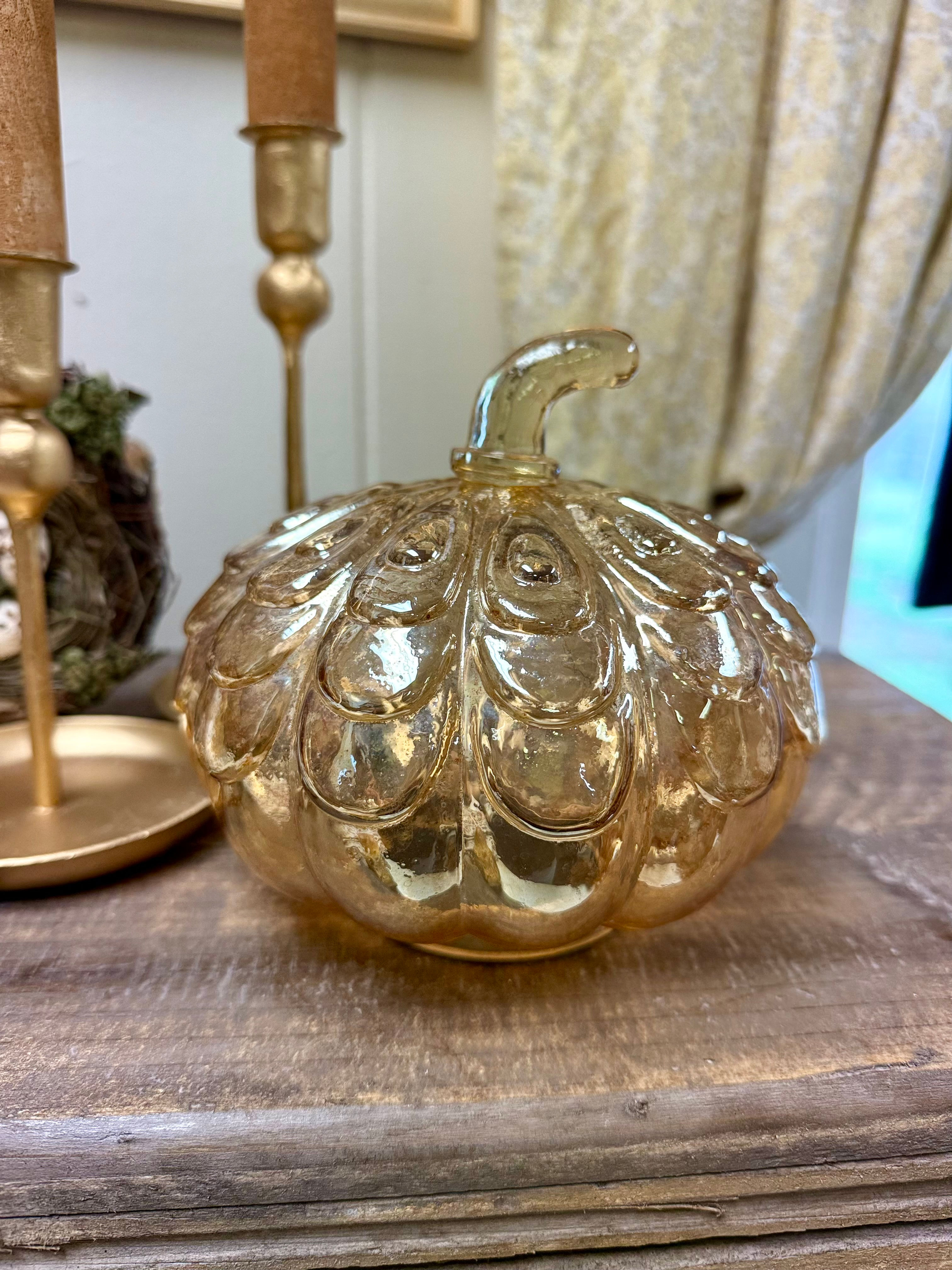 6" x 7" glass pumpkin with stem, golden hue to the glass, molded designs in the glass, flat bottom