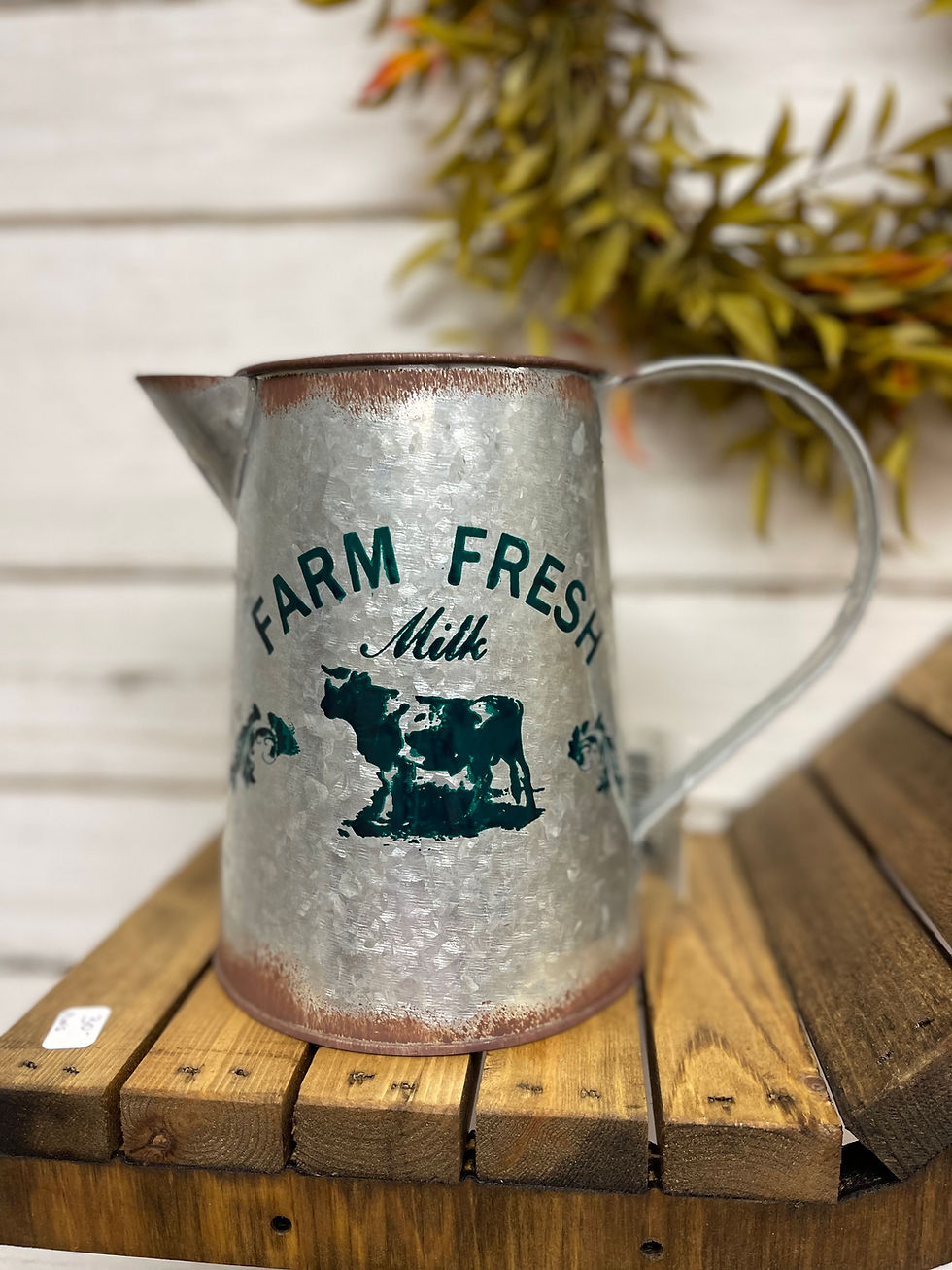 Galvanized metal pitcher with rust accents and a green cow motif. 6.75" tall x 5" diameter