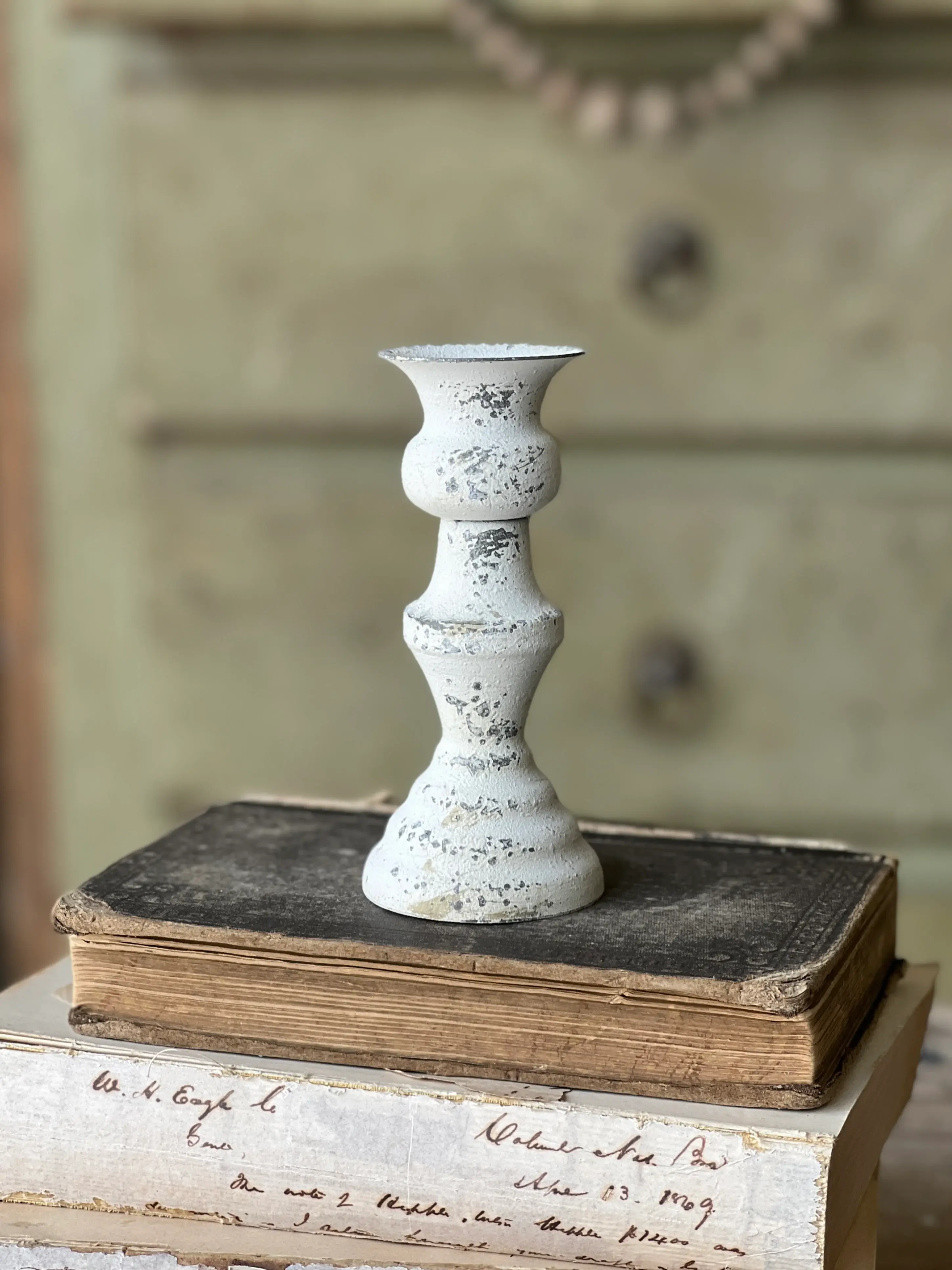 5.5" tall metal taper candle holder, white textured distressed finish, curvy spindle silhouette
