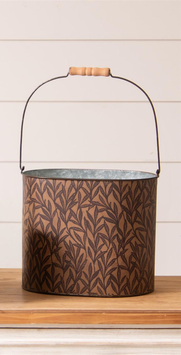 17" H x 11" W x 7.75" D, oval metal bucket with brown vine wallpaper wrap, metal handle with a wood hand grip