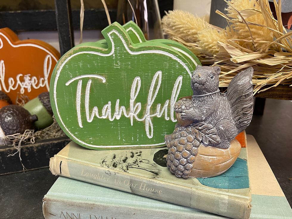 Green wooden pumpkin shaped block with the word thankful carved in the front