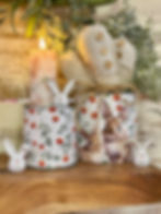 set of 2 metal cylinder buckets 4" & 5" tall, both wrapped in white background with orange floral design, 5" has 2 bunnies