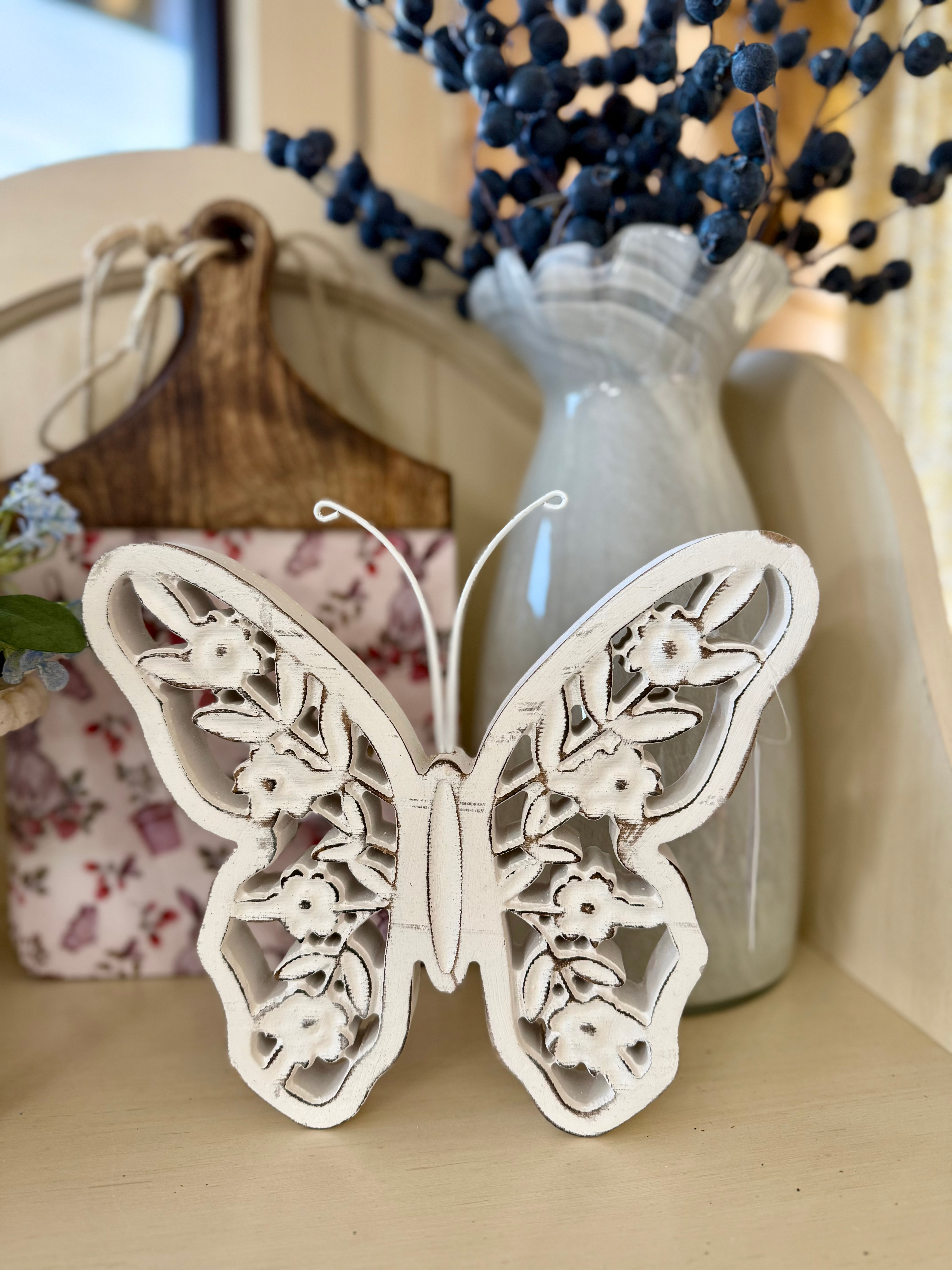 9.25" x 7.8" wood butterfly, distressed white, floral cutouts in wings, metal antennae, tabletop sitter