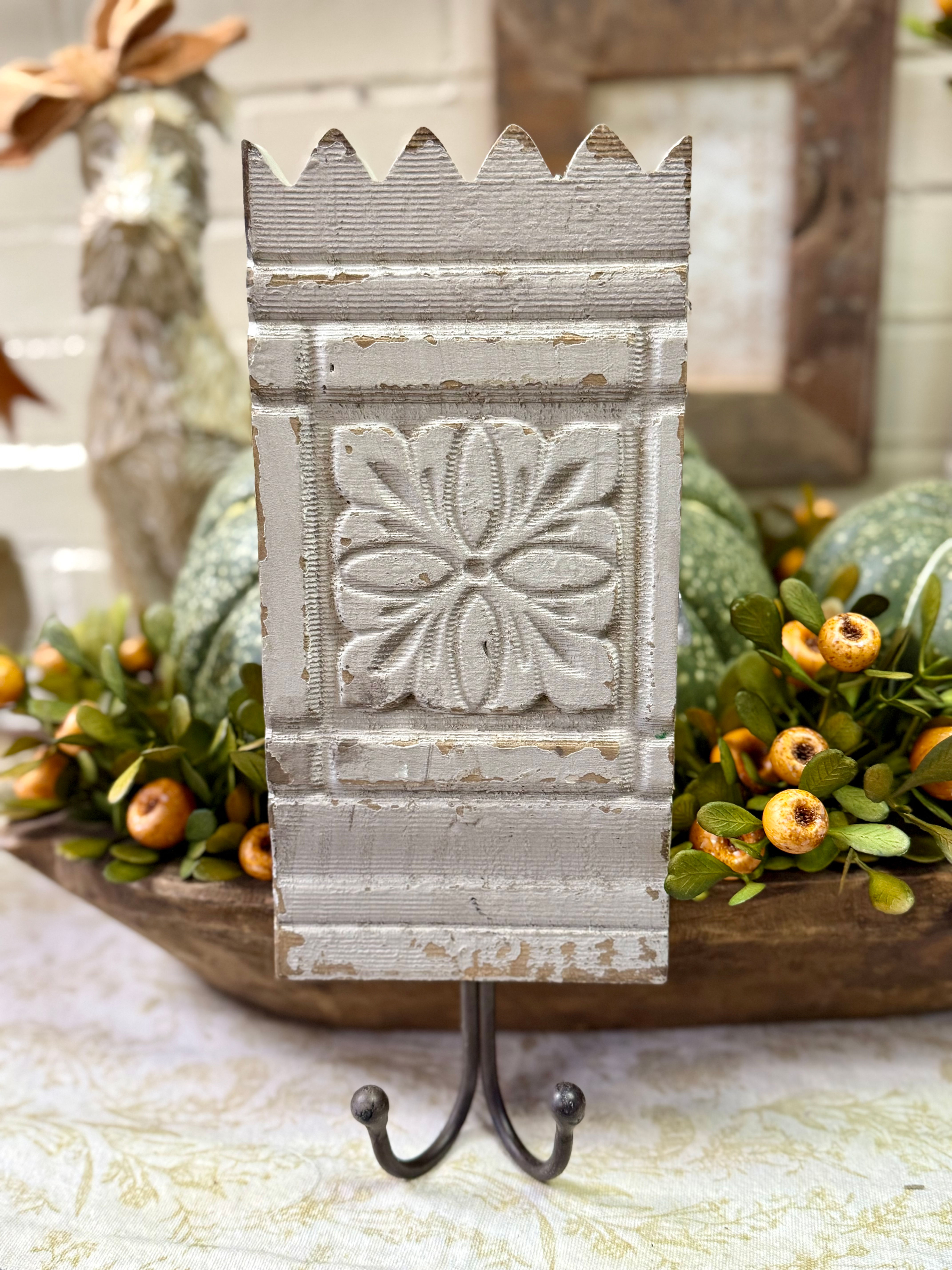 12" x 5" wood block with carved details, painted a chippy gray, iron double hook on bottom, 2 back loops for hanging