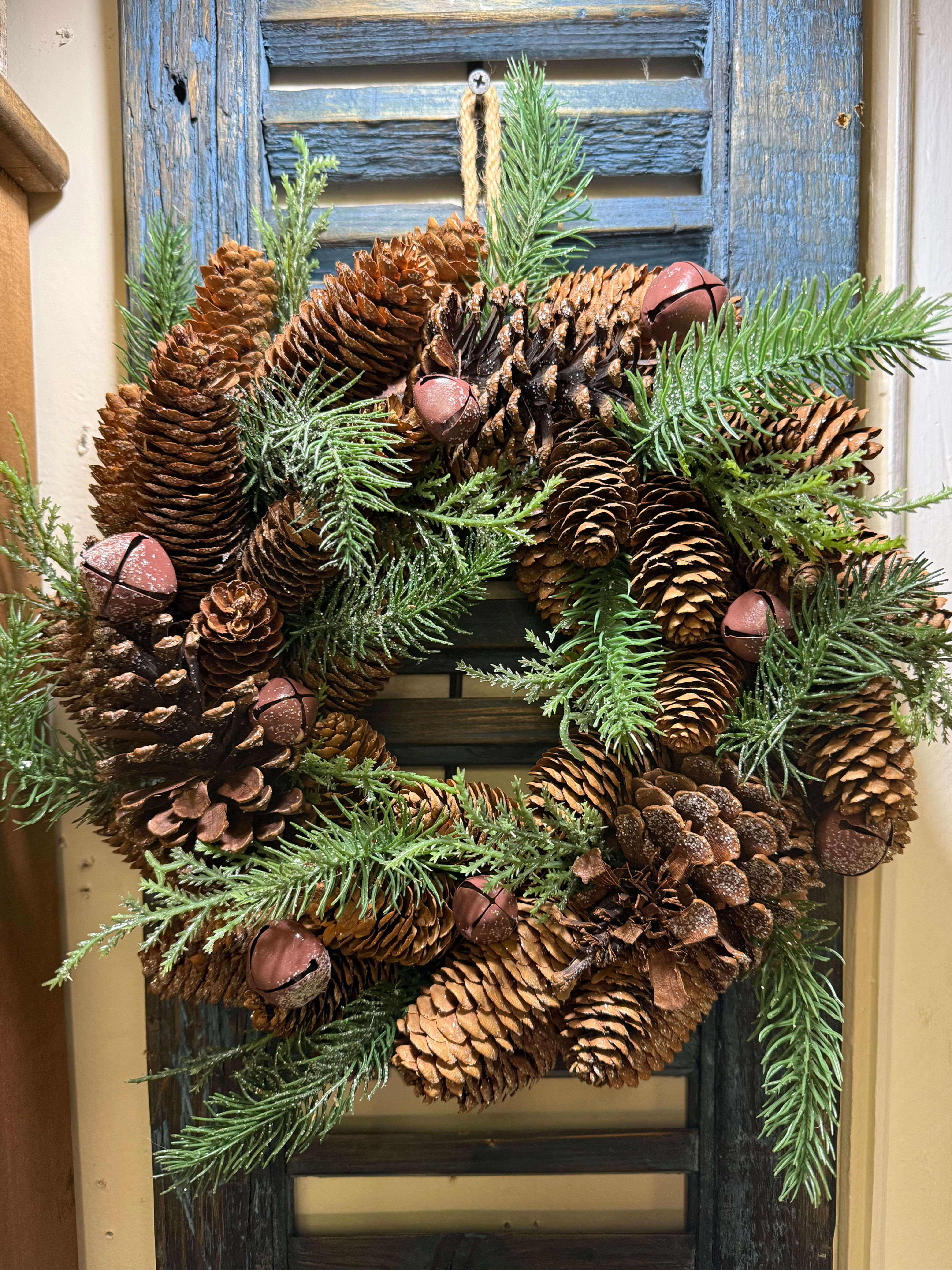 13 inch Christmas wreath with evergreen pine, pinecones and rustic rusty bell accents.