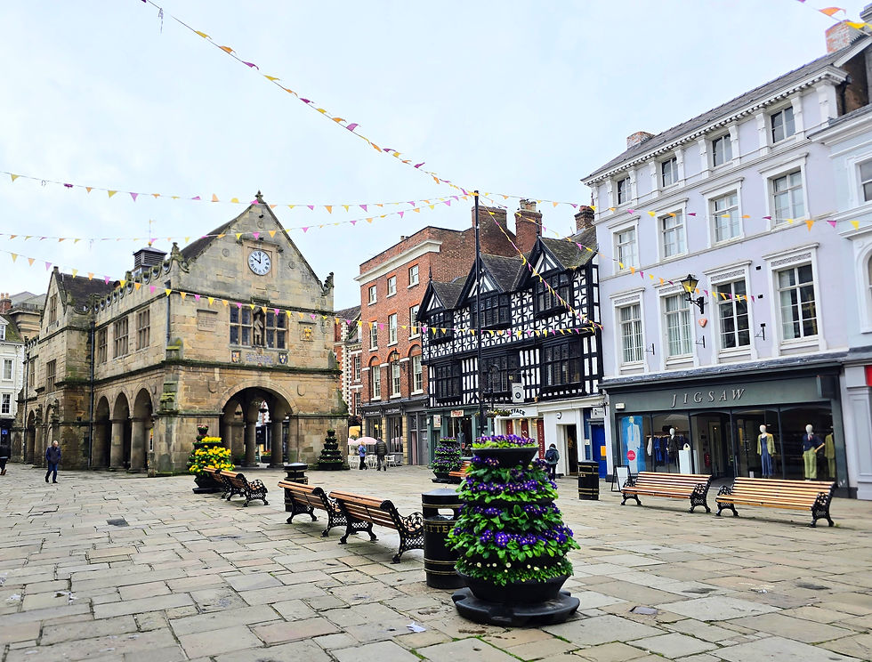Shrewsbury market place with benches and flowers.