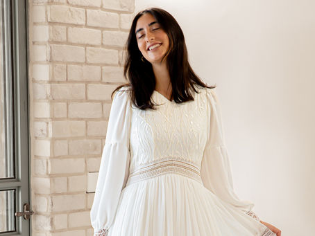 כלה עומדת בסלון עם שמלה מיוחדת עם שילובי בדים