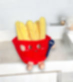 French fries plush dog toy on a white surface