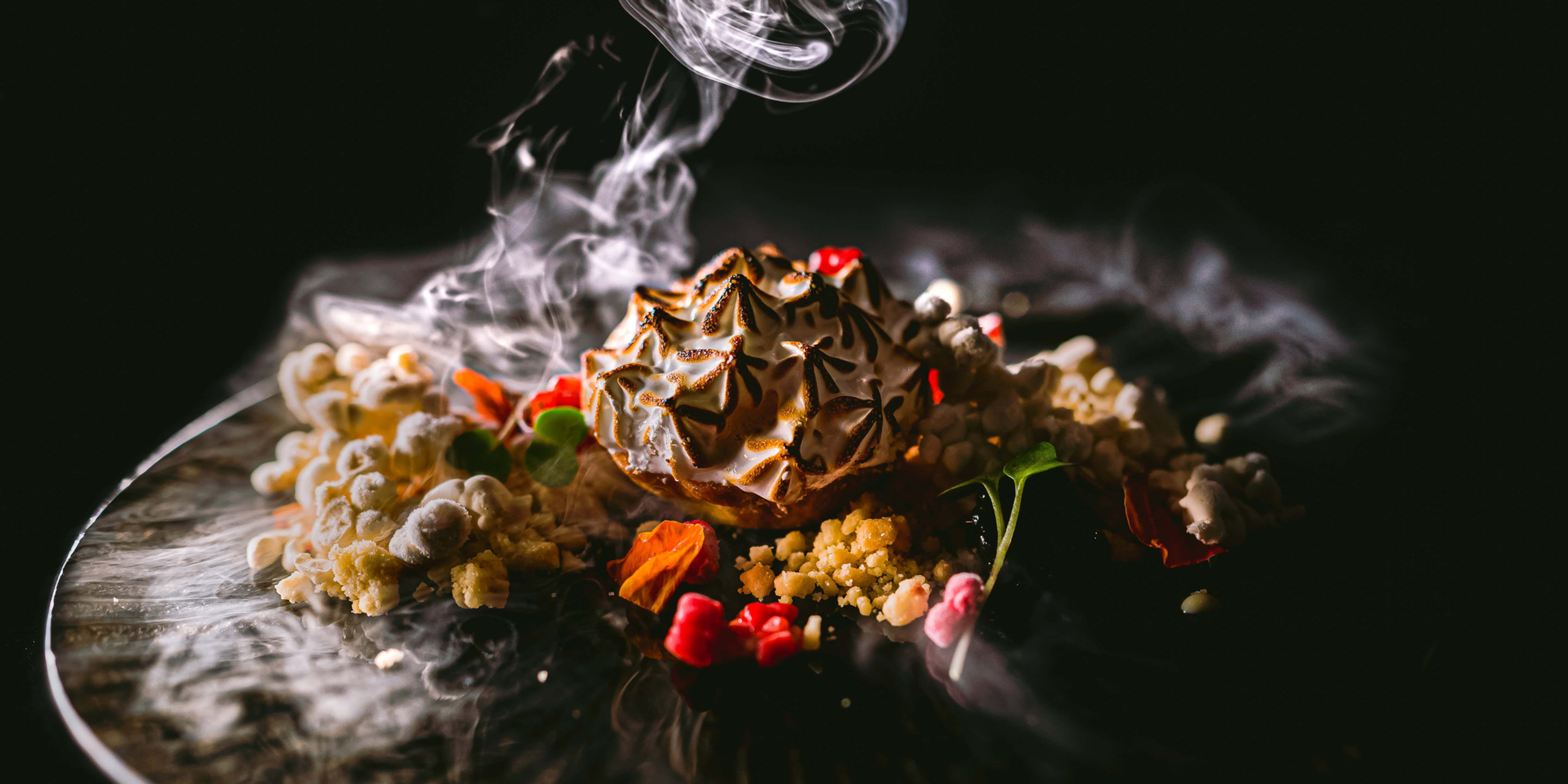 A plated dessert with smoke rising over it