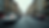 Blurred view of a busy urban street with moving cars. Tall buildings line both sides. The scene feels dynamic with subdued colors.