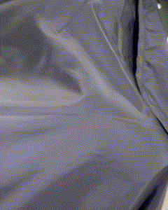 Close-up of a barber's cape with hair clippings, showcasing the detailed work and cleanliness of the barber's environment.
