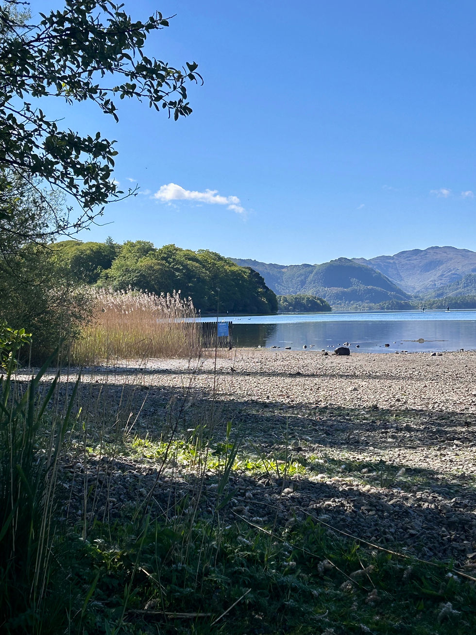 Eye-level view of a calm Scottish loch with a kayak on the water