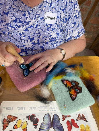 An image of a lady needle felting her blue butterfly at The Oast Studio