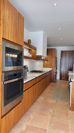 Kitchen with double wall ovens and wood cabinets at Casa Ganima, Playa Grande