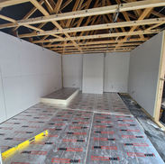 Insulated garage floor and insulated plaster boards fixed to timber frame work during a garage conversion in Whitley Bay, North Tyneside.