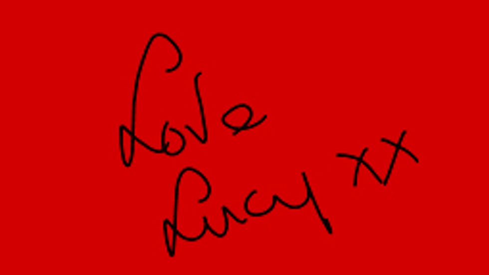 Black handwritten text "Love Lucy xx" on a red background, conveying a warm, affectionate mood.