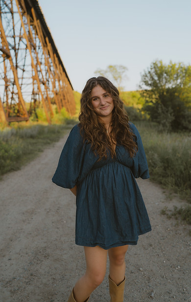 Woman in denim dress rustic backdrop