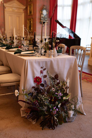 A dressed table for a wedding reception, with a beautiful floral meadow at the base