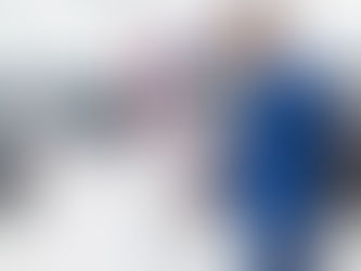 Man checking tire shop inventory on computer with tires behind him.