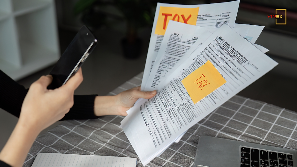 Person reviewing tax documents and forms, illustrating Vietnam tax compliance 2025 requirements for new and foreign-owned businesses.