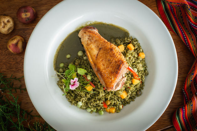 Plato gourmet con pollo, arroz y vegetales en un restaurante Kay Pacha.