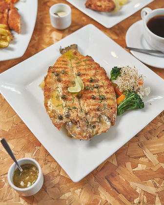 Salmón a la plancha en plato blanco, con verduras y salsa. Restaurante en Huaraz.