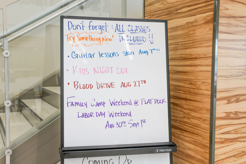 Whiteboard with announcements: ALL CLASSES, Guitar lessons, BLOOD DRIVE, Family Camp.