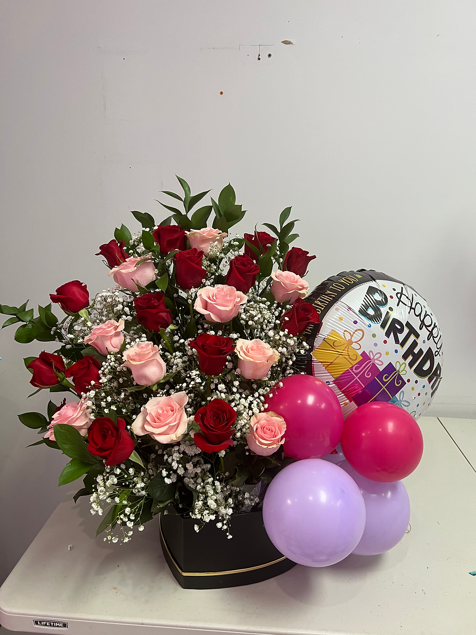 Red and pink rose arrangment with balloons