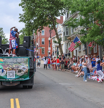 The Parade Man engaging a diverse crowd during community parade brand activation in Charlestown, Boston, MA — live street marketing and sponsor visibility for local businesses.