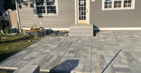 Backyard walkway with stone pavers and masonry steps.