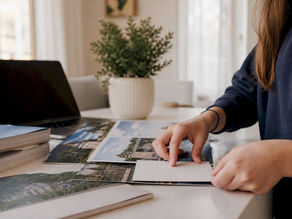 Hands organizing college brochures and spreadsheet