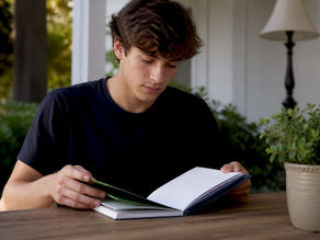 Student hands near planner and laptop on desk