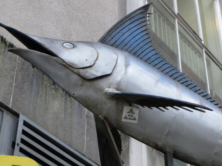 Metal sculpture of a swordfish attached to a wall in London.