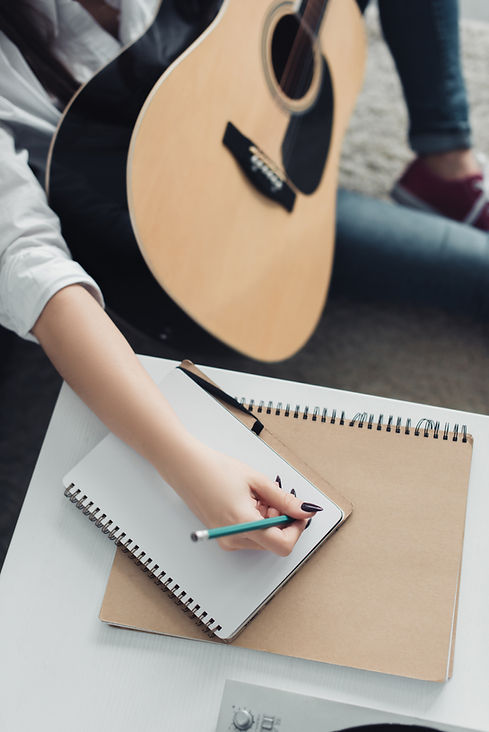 cropped-view-of-girl-with-acoustic-guitar-writing-2023-11-27-04-51-02-utc.jpg