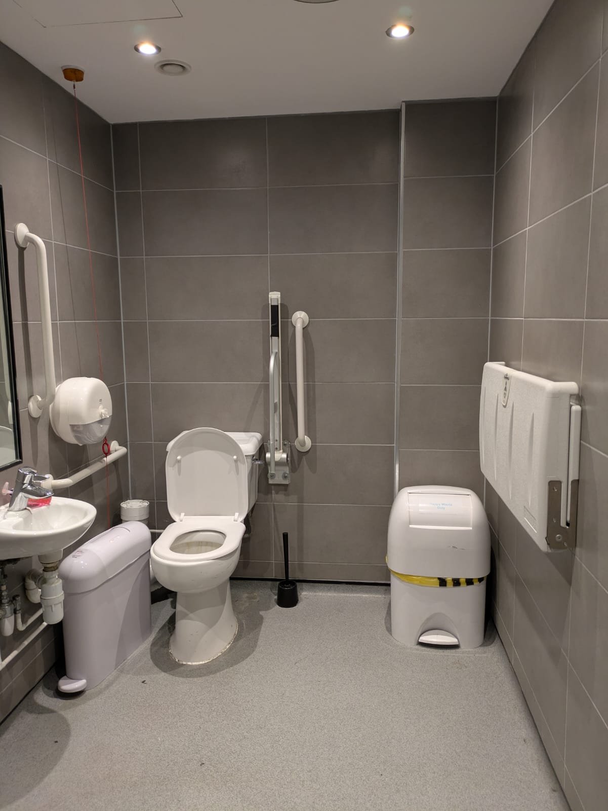 The accessible toilet on the fourth floor, with grab rails beside the toilet and the basin.