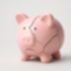 Sad-looking cracked piggy bank that means impending financial failure.