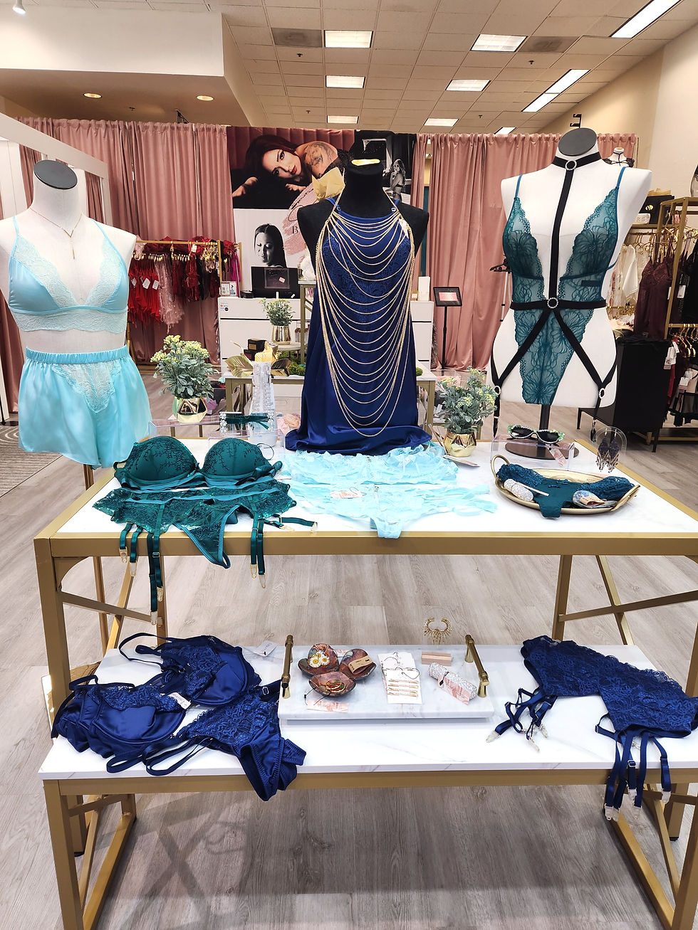 Lingerie display table at The Lingerie Lounge in Sierra Vista featuring colorful teddies, corsets, and accessories in teal, navy, and lace.