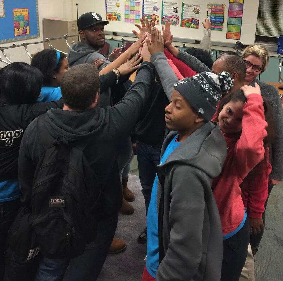 People standing with hands up in a circle