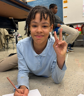 Young girl reading and writing at Homewood Children's Village