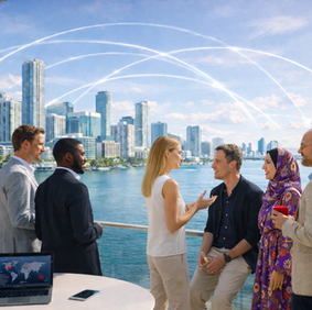 A diverse group of founders, investors, and advisors in modern businesswear stand on a Miami waterfront terrace overlooking the Brickell skyline and Biscayne Bay, with subtle global connectivity arcs symbolizing cross-border startup expansion and investment.