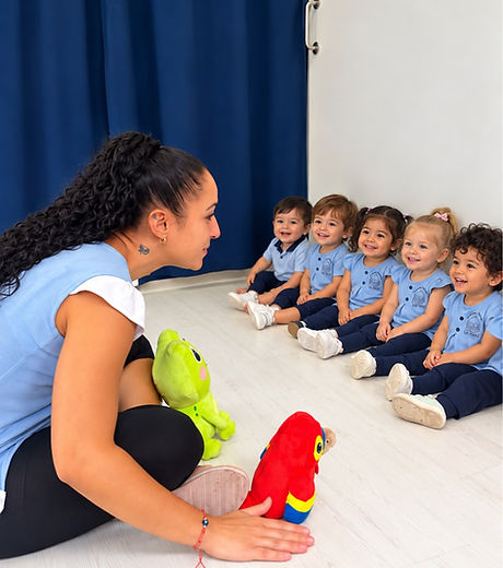 Educadora jugando con marionetas junto a los niños de Escuela Infantil Carrusel