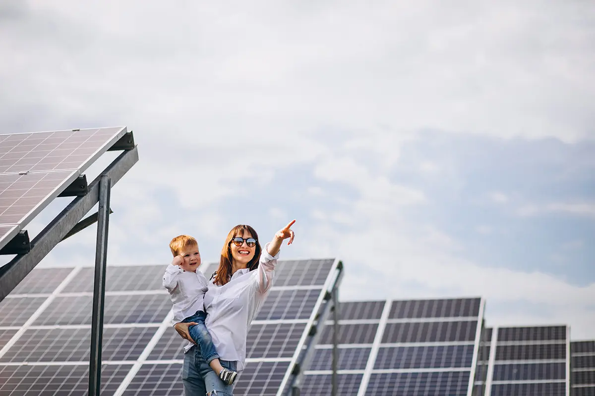 Une mère et son fils au milieu d'une ferme de panneaux solaires