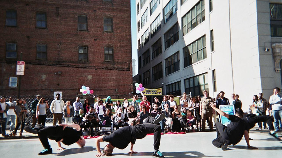 break dancers perform outside at a block party