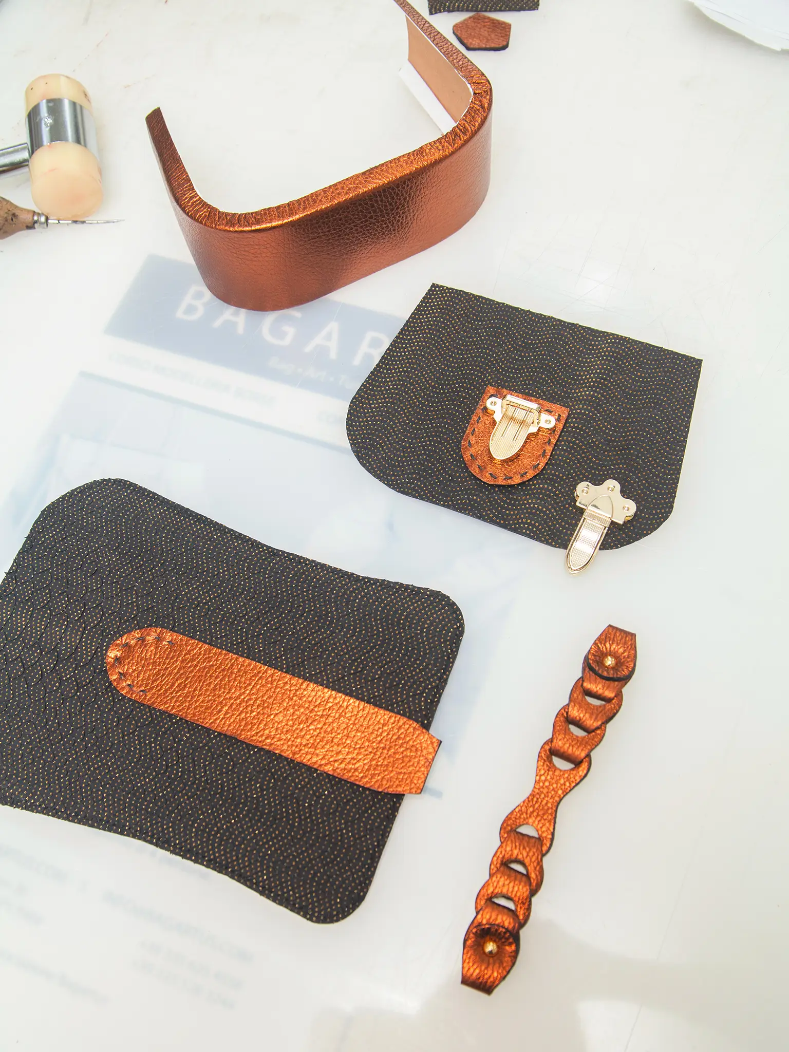 table full of leather tools and leather bag pieces ready to be assembled