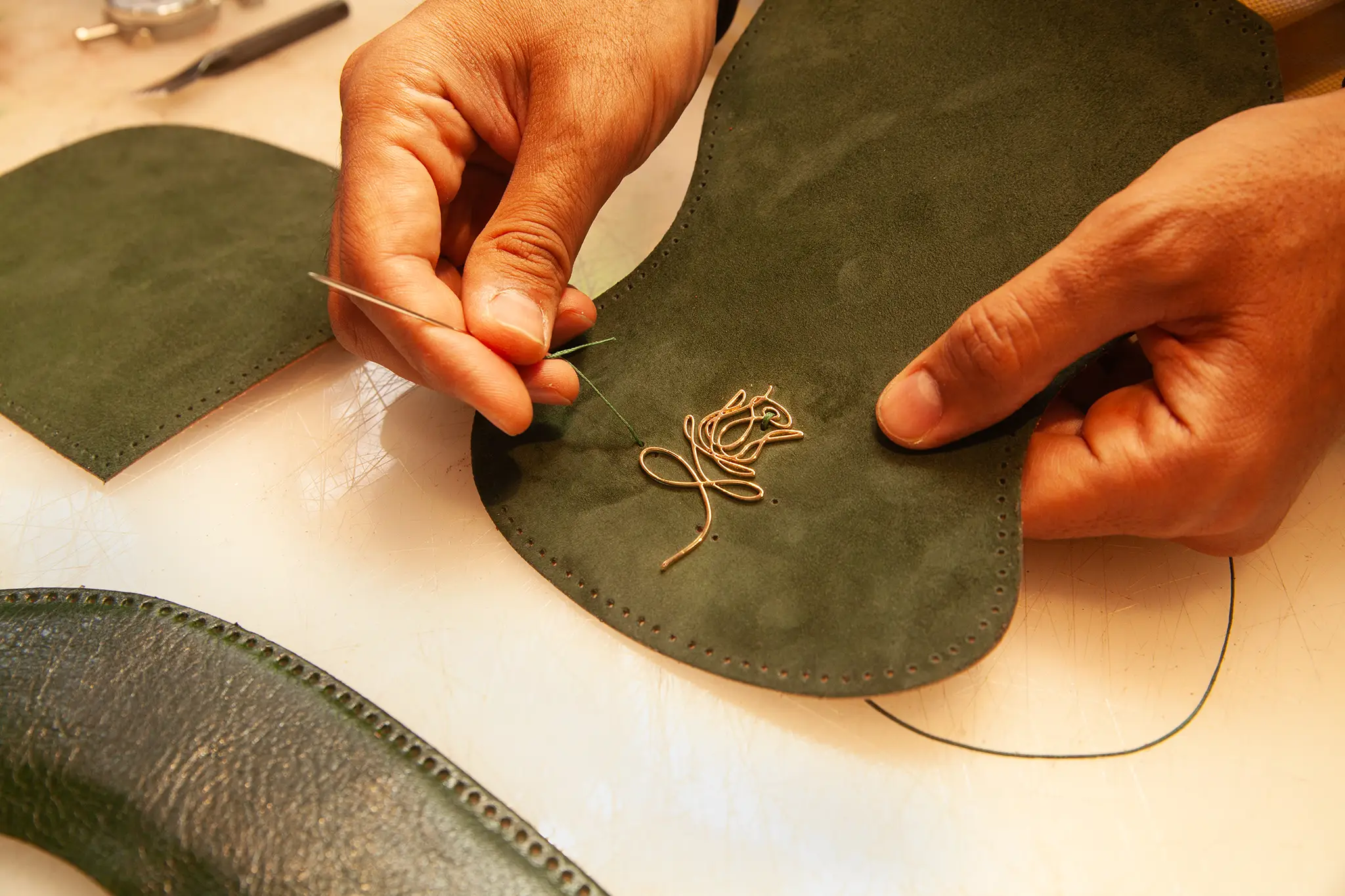 close up of the artisan hand sewing a leather bag