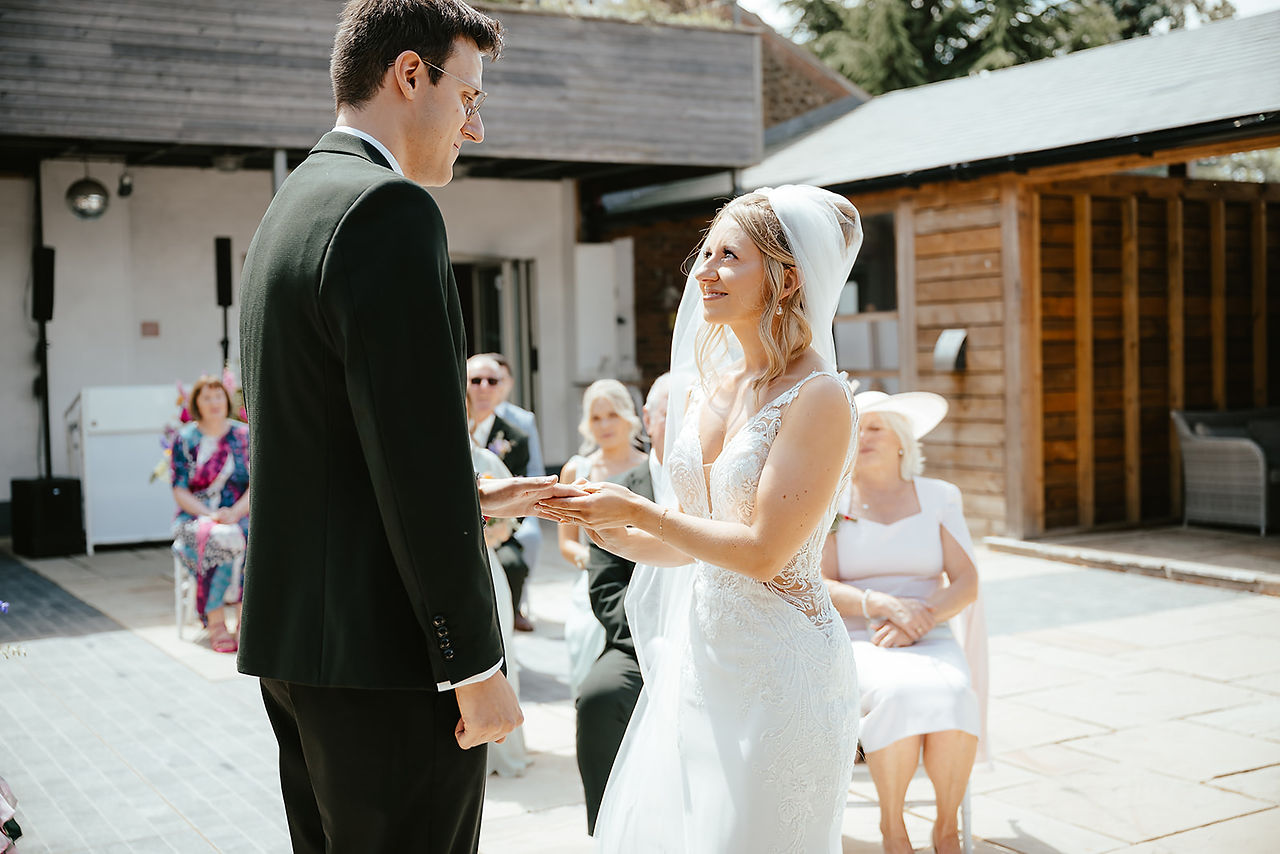 bride placing the grooms ring on his finger