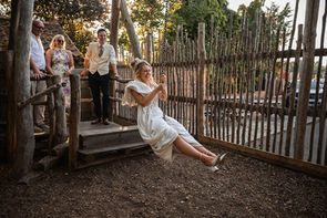 bride screaming and laughing as she goes down the zip line dress slung over her sholder