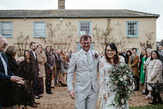 confetti-madness-at-south-farm-cambridge-all-guest-lined-up-outside-the-house-red-flower-pettles-hitting-bride-groom-face